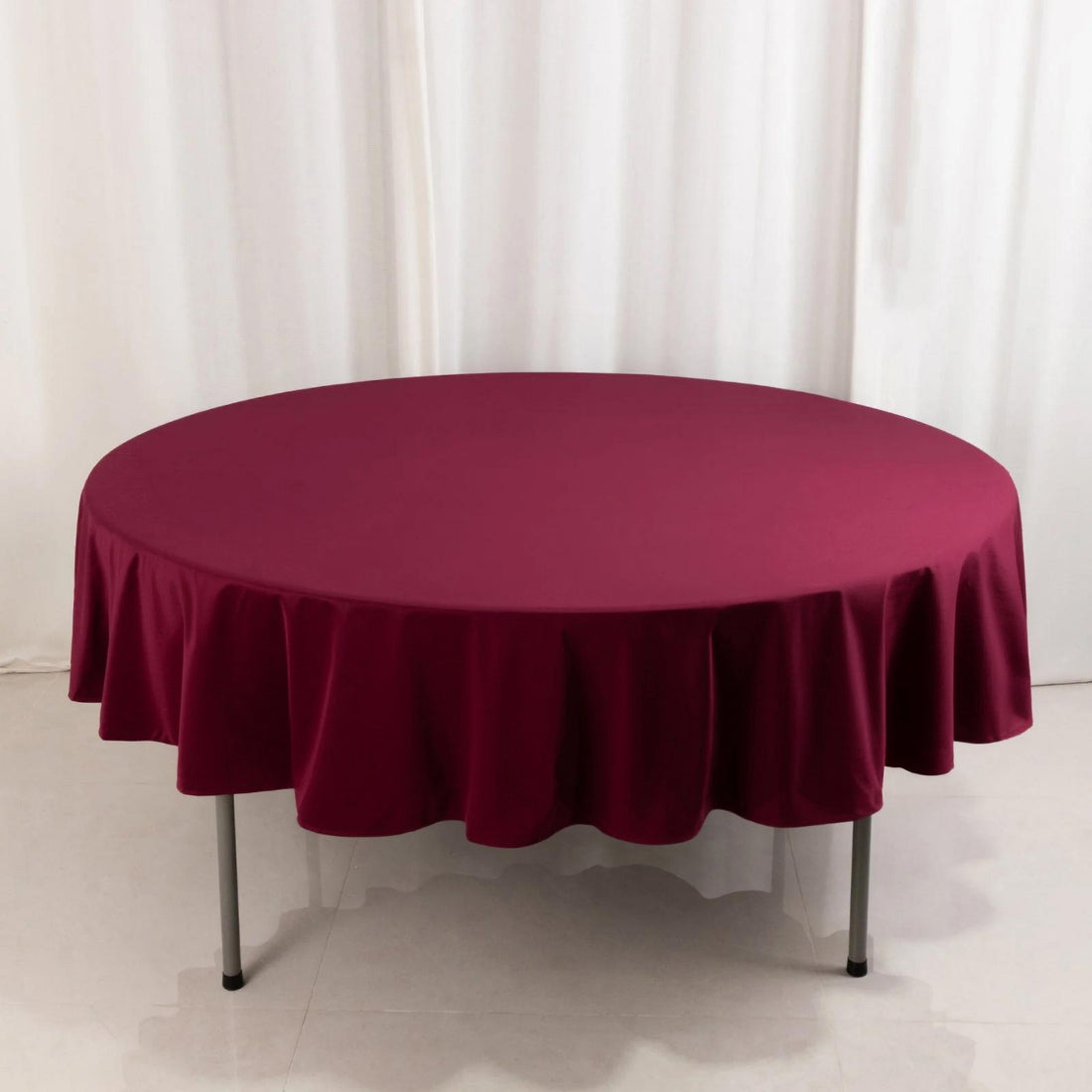 Round burgundy tablecloth draped elegantly over a table