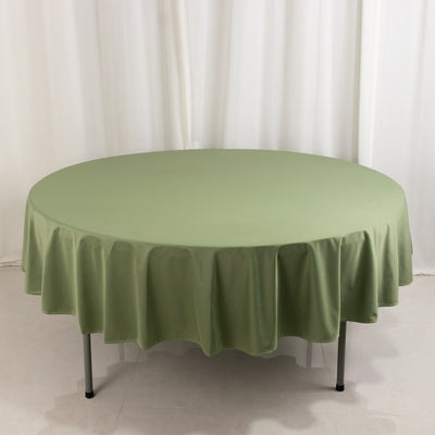 Round green tablecloth on a circular table against a plain backdrop