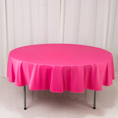 Round pink tablecloth draped over a table in a studio setting.