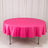 Round pink tablecloth draped over a table in a studio setting.