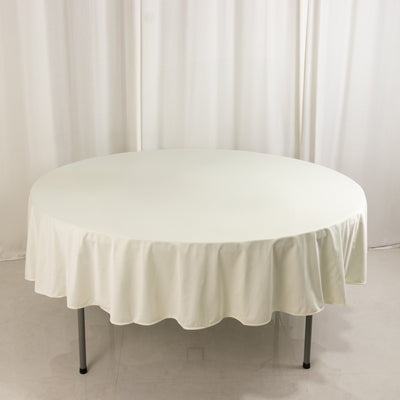 Round white table with a scalloped tablecloth