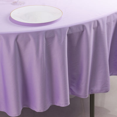 Purple tablecloth draping elegantly over a round table with a white plate.