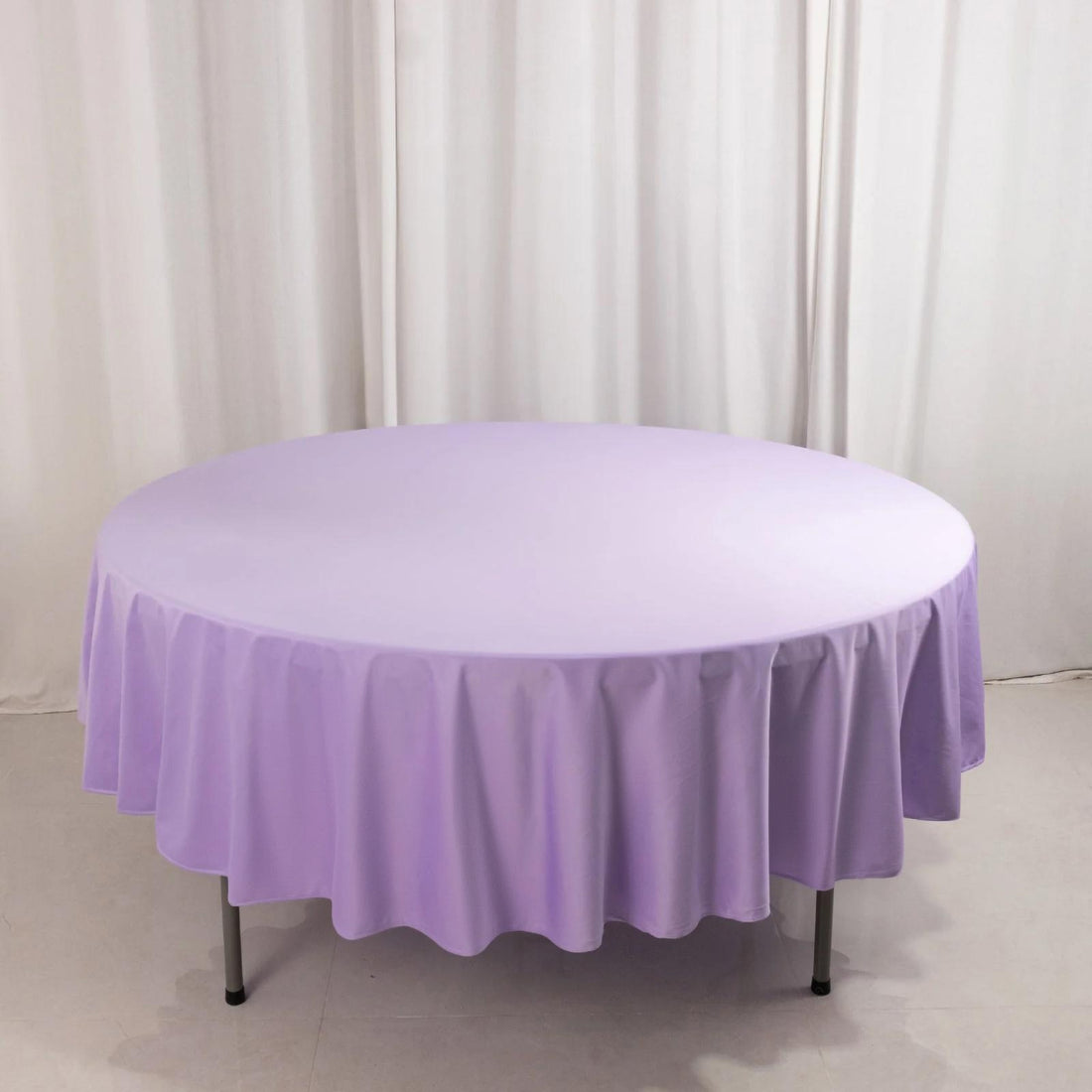 Lavender round tablecloth on a table against a plain backdrop