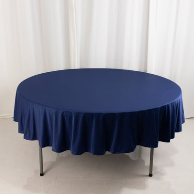 Navy round tablecloth with pleated edges on a plain backdrop