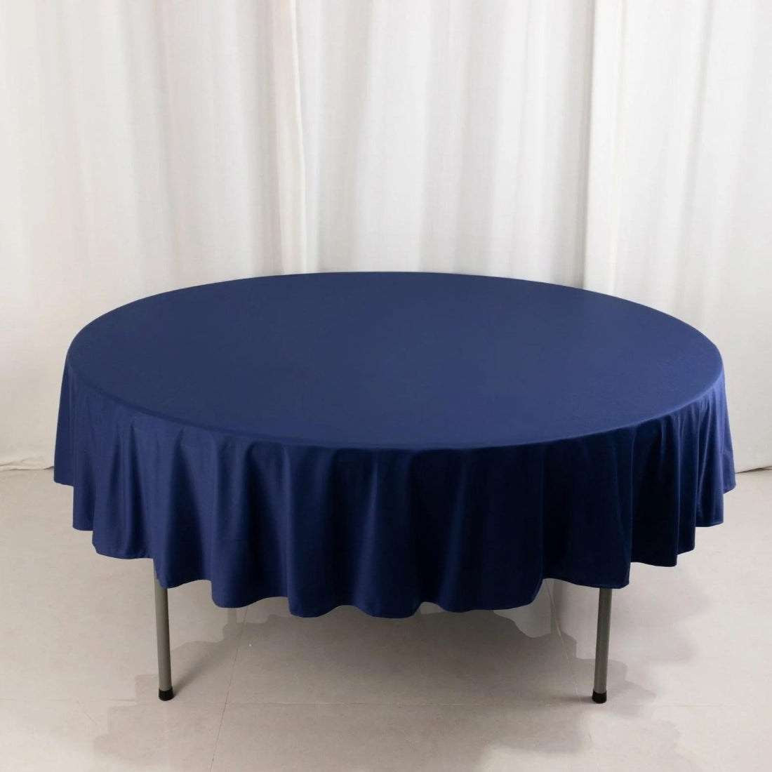 Round navy tablecloth on a circular table, draped elegantly.