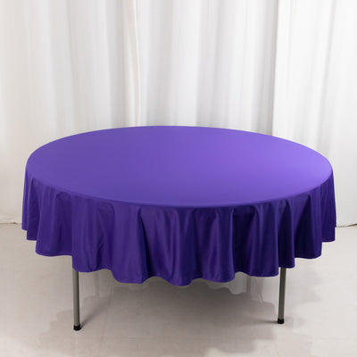 Purple round tablecloth on a white backdrop.