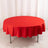 Red round tablecloth with scalloped edges on a plain backdrop.