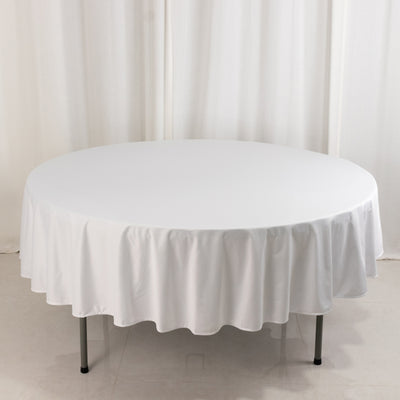 Round white tablecloth draped over a circular table.