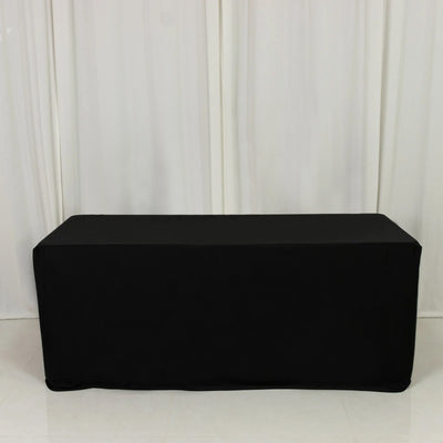 Black table cover draped over a rectangular table in studio setting.