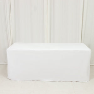 White table cover draped over a rectangular table in a studio setting.