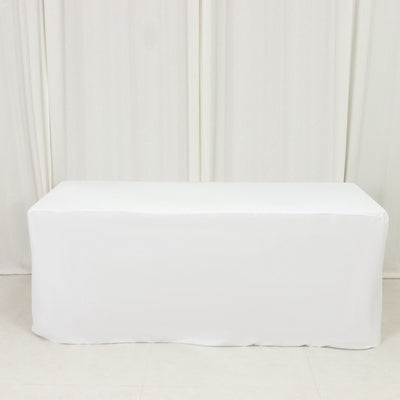 White table cover draped over a rectangular table in a studio setting.