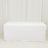 White table cover draped over a rectangular table in a studio setting.