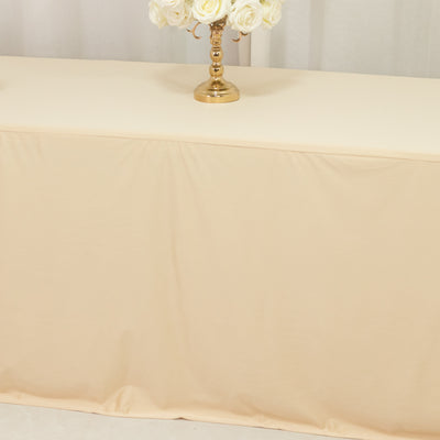 Beige tablecloth draped over a table with a gold vase of white roses.