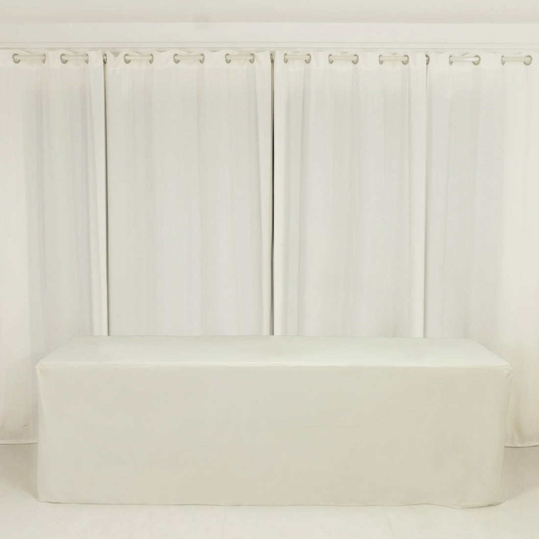 White table cover draped over a table in a bright, minimalistic setting.