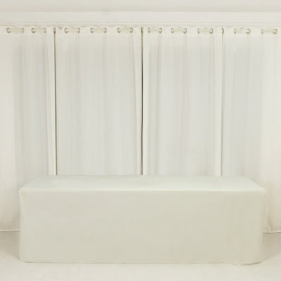 White table cover draped over a table in a bright, minimalistic setting.