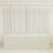 White table cover draped over a table in a bright, minimalistic setting.