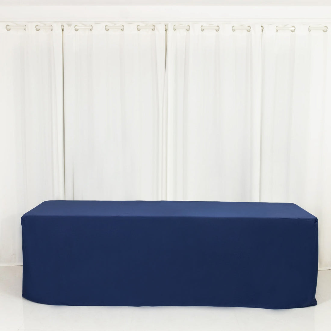 Navy blue tablecloth draped over a long table against a white backdrop