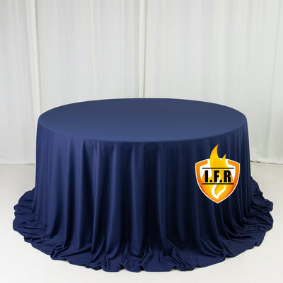 Navy blue round tablecloth on display table with white curtain backdrop