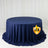 Navy blue round tablecloth on display table with white curtain backdrop