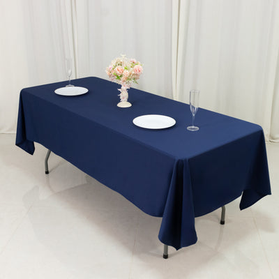 Navy blue tablecloth draped on a table with plates and glasses