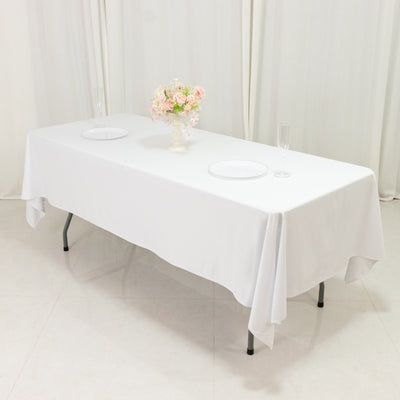 Elegant white table setting with a floral centerpiece and glassware.