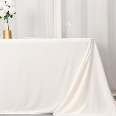 Elegant white tablecloth draped on table with decorative elements.