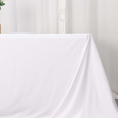 White tablecloth draped elegantly over a table in a minimalistic setting.