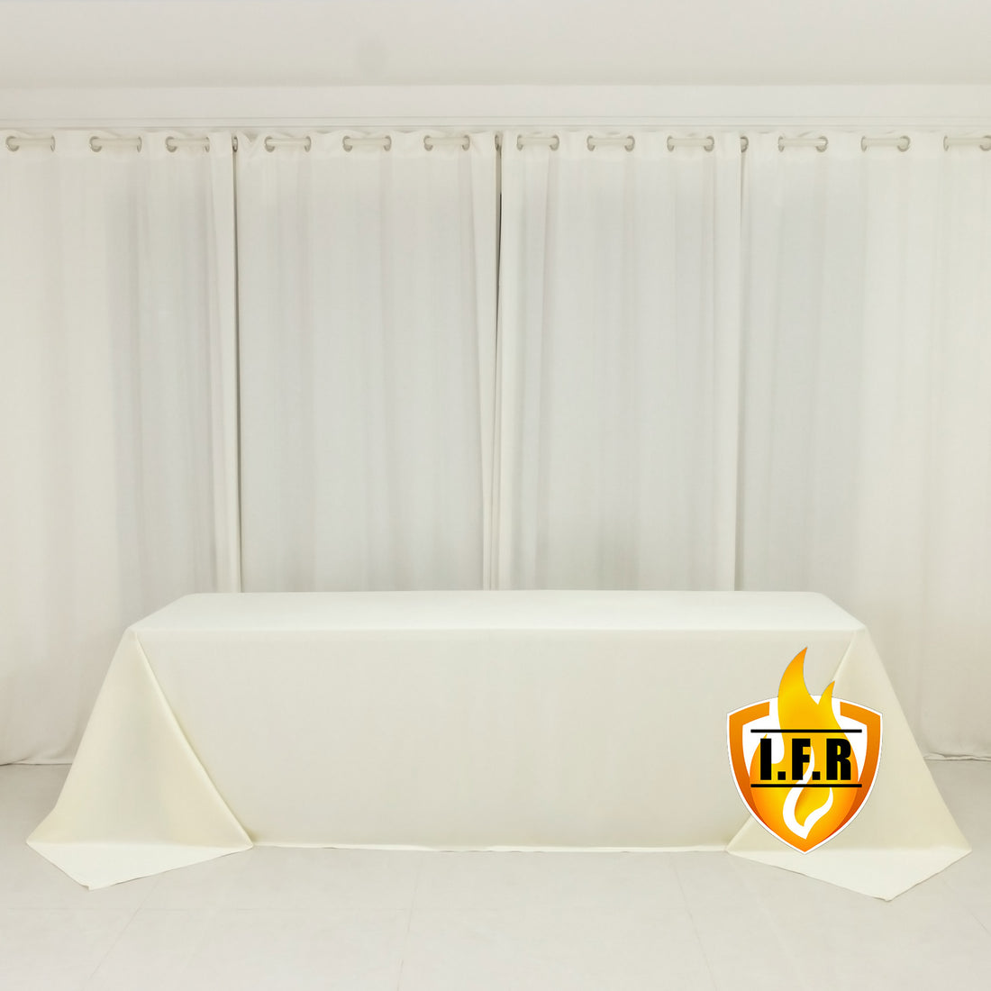 White table with a draped tablecloth in a clean, minimalist setting