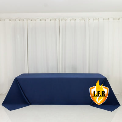 Navy tablecloth draped on a table in front of white curtains