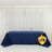 Navy tablecloth draped on a table in front of white curtains