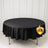 Black round tablecloth on display table with white curtain backdrop