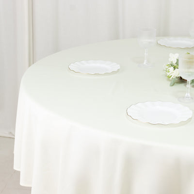 Elegant round table set with white scalloped plates and floral centerpiece.