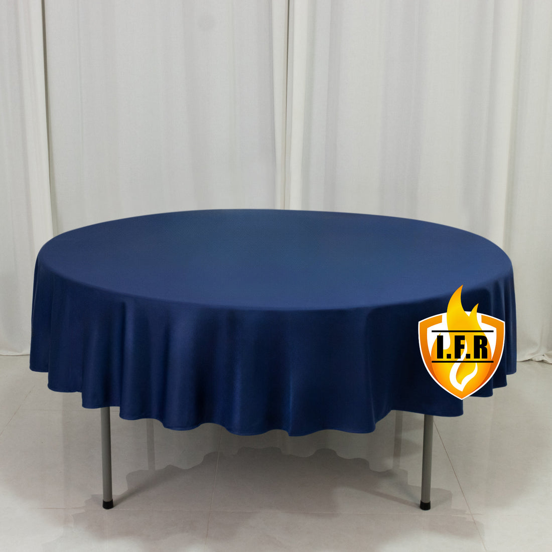 Round navy tablecloth on a round table with a smooth finish. 