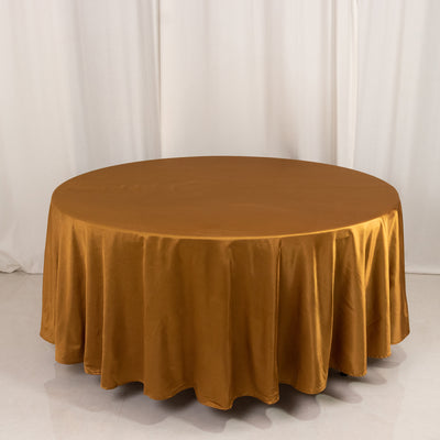 Round golden tablecloth on a plain backdrop.