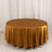 Round gold tablecloth with elegant drape on a plain backdrop.