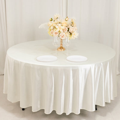 Round table with elegant white tablecloth and floral centerpiece.