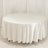 Round table covered with a white tablecloth in a studio setting.