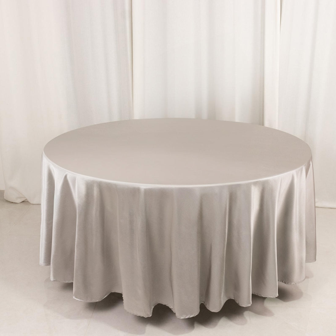 Round silver tablecloth on a plain background.