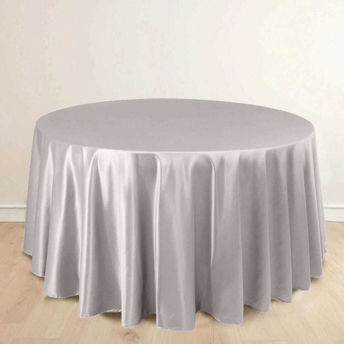 Round table covered with a soft grey tablecloth.