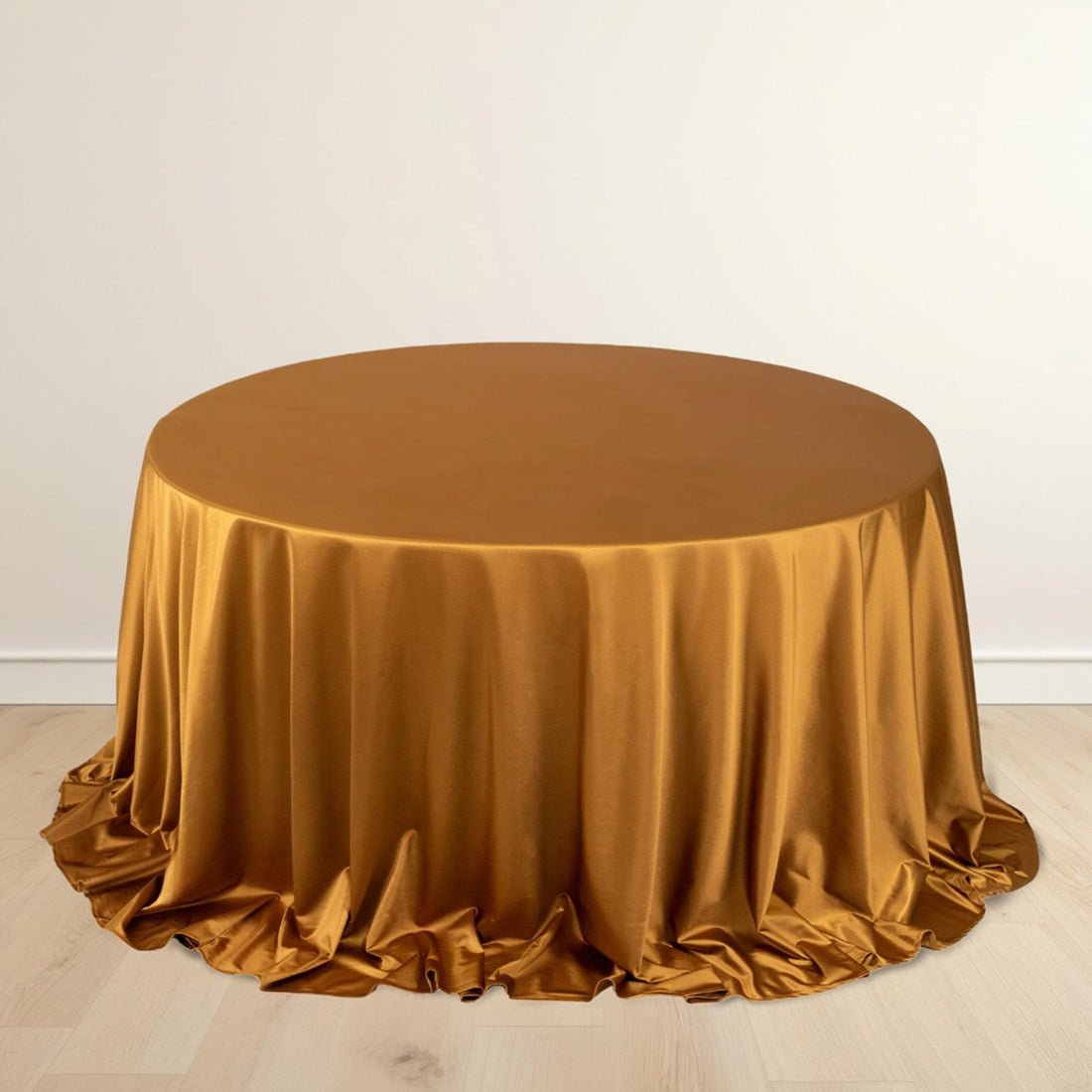 Round gold satin tablecloth with elegant draping.