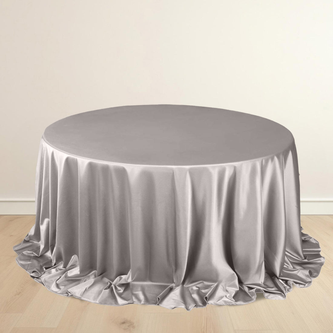 Silver round tablecloth with elegant draping fabric.