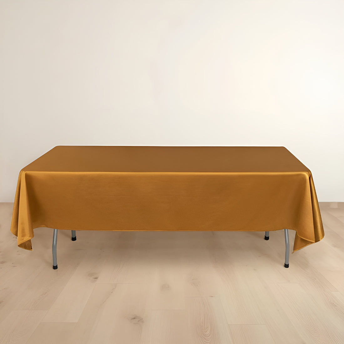 Gold tablecloth on a table with a plain backdrop