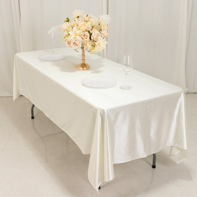 Elegant white table setting with floral centerpiece and wine glass.