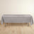 Gray tablecloth draped over a table on a light wooden floor.