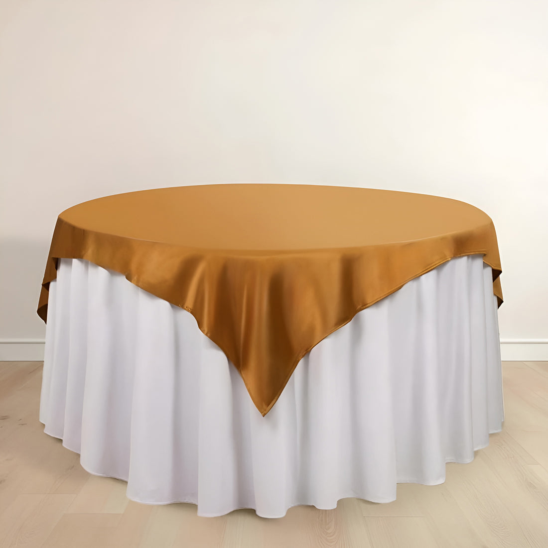 Round table with a gold satin tablecloth and white skirt