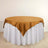 Round table with a gold satin tablecloth and white skirt