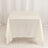 White satin tablecloth on a table against a plain backdrop