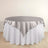 Round table with elegant gray satin overlay on white tablecloth