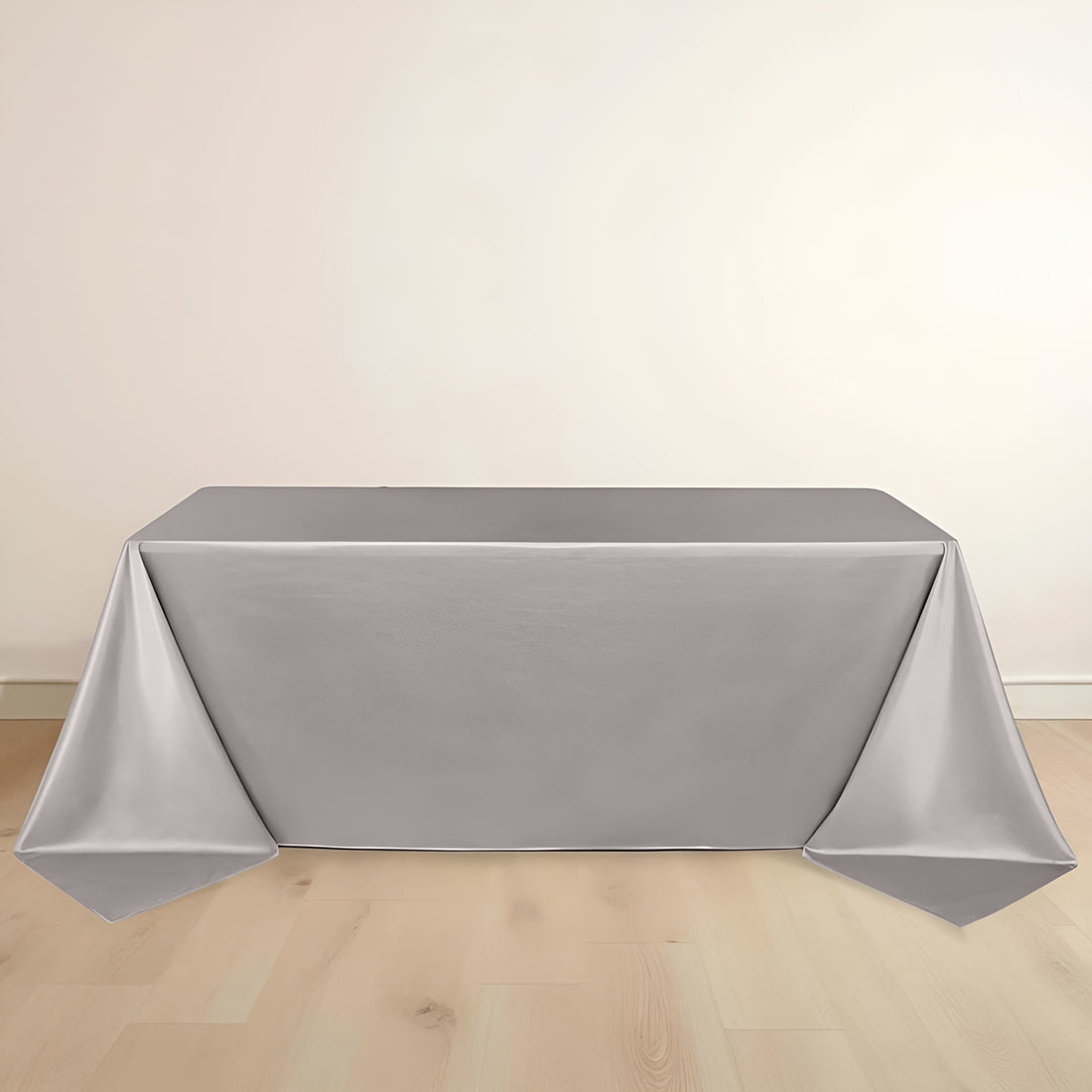 Gray tablecloth draped over a table against a plain backdrop