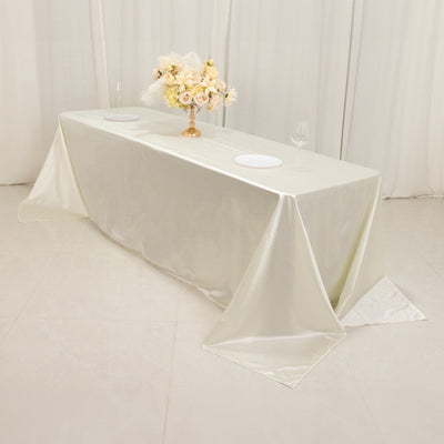 Elegant ivory tablecloth on a banquet table with floral centerpiece and dinnerware.